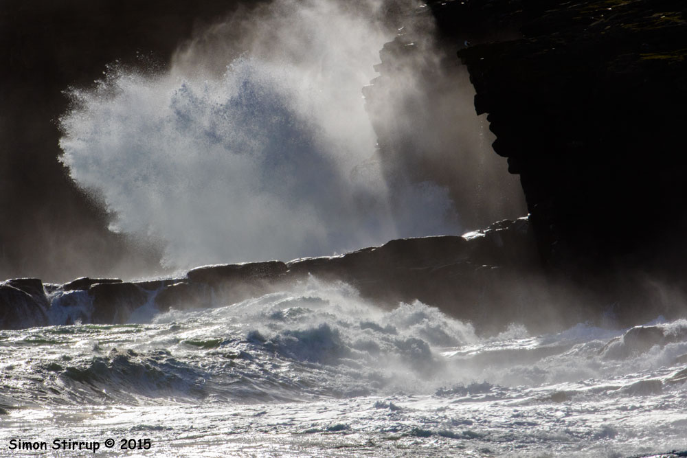 Wave crashing into cliffs